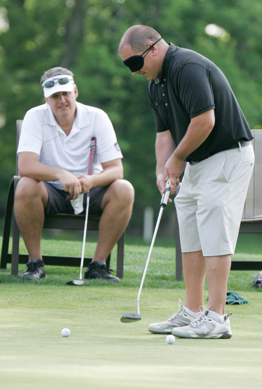 William D. Lewis The Vindicator John elias of Canfield tries putting while blindfolded during GGOV Scramble 5-21-18 at Tippecanoe. Looking on is Brian Cross.