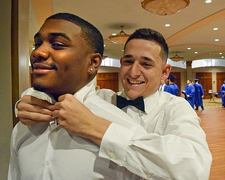 William D. Lewis The Vindicator Hubbard graduate Tyreq Moorer (correct), left, gets help with his tie from fellow grad John O'Hara prior to commencement at Stambaugh Auditorium 5-23-18.