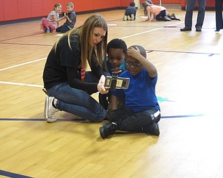 Neighbors | Zack Shively.The Austintown Elementary students used phones from Google to look at different objects in 3D, such as a grasshopper and a tornado, through Google's Expeditions app. The app can be used by teachers on any device with a dual lens camera. Pictured, aide Sam Mehle looks at an object with students Jackson and Kalen.