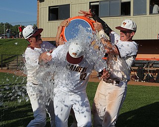 Brandon Youngs (27,left) and Brycen James (5) of South Range dump a cooler of ice water over their head coach Jim Hanek after their victory in Friday nights Regional Finals matchup against Grand Valley at Massilon High School. Dustin Livesay  |  The Vindicator  5/25/18  Massilon.