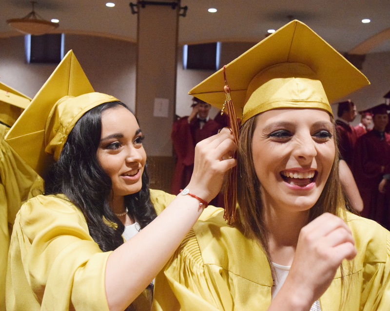 William D. Lewis The Vindicator Mooney grad Olivia Saunders(right) gets some help with her cap from fellow grad Angelina Toss before 5-27-18 commencement at Stambaugh.