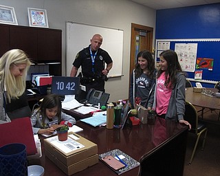 Neighbors | Zack Shively.First-grade student Jayde Simon travelled with principal Michael Masucci and resource officer Steve Kent to the high school and middle school. At the middle school, she met with assistant principal Lisa Iberis and called her sisters down to the office. She said the best part of the day was seeing her sisters. She wrote a "no homework" pass for her them. Pictured are Iberis, Simon, Kent and her sisters Neela and Maren Simon.