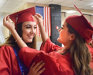 William D. Lewis The Vindicator  Canfield grad Madeline Remby, left, gets help with her motarboard from Sarah Veverka before 6-1-18 commencement at CHS.