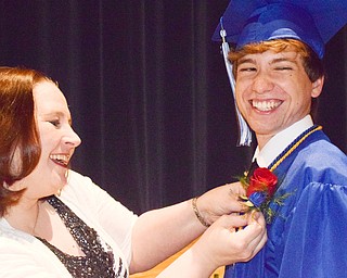 William D. Lewis  The Vindicator  Poland grad Zach Howard is all smiles as Poland teacher Julie Walsh pins a flower on his gown prior to commencement 6-2-18.