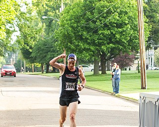 Scott R. Galvin | The Vindicator.Mack Mettille of Canfield celebrates as he crosses the finish line first in the 5K run at the first inaugural Youngstown Marathon on Sunday, June 3, 2018.