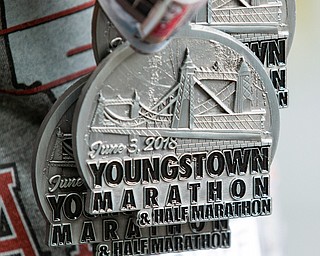 Scott R. Galvin | The Vindicator.A worker with the Youngstown Marathon holds medals for participants of the marathon and half-marathon run on Sunday, June 3, 2018.