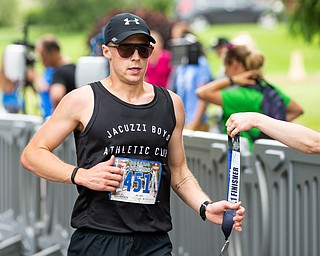 Scott R. Galvin | The Vindicator.Jon Hutnyan of Baltimore, Maryland, receives his medal for crossing the finish line first in the half marathon run during the first inaugural Youngstown Marathon on Sunday, June 3, 2018.