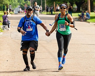 Scott R. Galvin | The Vindicator.Dwayne Dickens of Maryland holds hands with Misty Lawson of Virginia as they cross the finish line of the half marathon together during the first inaugural Youngstown Marathon on Sunday, June 3, 2018.