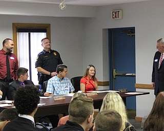 Neighbors | Abby Slanker.A Canfield High School student read a report as City Manager Wade Calhoun, Police Chief Charles Collucci and Canfield Mayor Richard Duffett looked on during a mock City Council meeting, which was conducted as part of the school’s 38th annual Civic Day sponsored by the Rotary Club of Canfield.