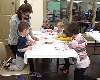 Neighbors | Zack Shively.The "Smart Money Story Time" was one of many PLYMC programs to work on children's financial literacy. Each child received a piggybank at the end of the event. Pictured, the children at the event made a wallet craft from paper.