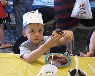 Neighbors | Zack Shively.The Austintown library celebrated National Doughnut Day with a program centered around doughnuts. Attendees of the program received plain doughnuts to decorate with icing and sprinkles. Pictured, Damien Caspary made a doughnut with chocolate icing.