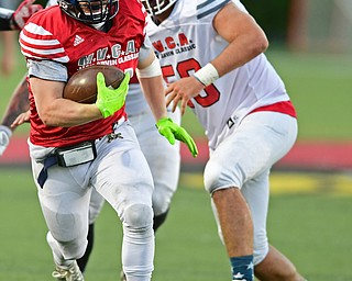 CANFIELD, OHIO - JUNE 14, 2018: Trumbull County's Alex Clark runs the ball away from Mahoning County's Steven Amstutz during the second half of the Jack Arvin All Star Football game, Thursday night at Canfield High School. DAVID DERMER | THE VINDICATOR