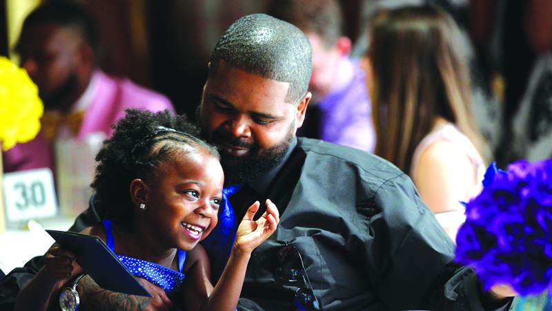 Na’Tyce Byers smiles as she sits with her dad, Kenric Littles, both of Youngstown, at Warriors Inc.’s inaugural Daddy Daughter Dance Saturday at the Saxon Club in Youngstown.