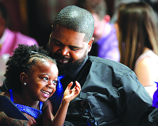 Na’Tyce Byers smiles as she sits with her dad, Kenric Littles, both of Youngstown, at Warriors Inc.’s inaugural Daddy Daughter Dance Saturday at the Saxon Club in Youngstown.