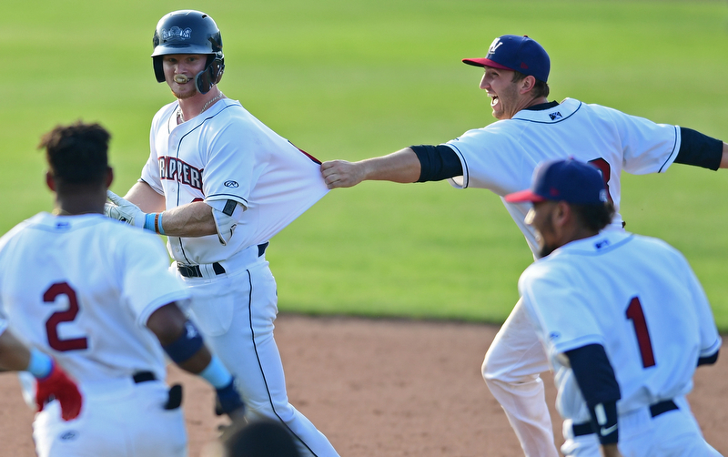 NILES, OHIO - JUNE 17, 2018: Mahoning Valley Scrappers' Mitch Reeves, left, is mobbed by his teammates Simeon Lucas, Hosea Nelson and Elvis Perez after hitting a game winning single in the ninth inning of a baseball game against the West Virginia Black Bears, Sunday afternoon. The Scrappers won 10-9. DAVID DERMER | THE VINDICATOR