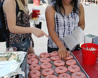 Macie Gingerich (left) and Jolie Madigan (right) both of Heartsville, Ohio pick out Strawberry donuts during the Strawberry Festival at White House Fruit Farms in Canfield on Sunday afternoon.  Dustin Livesay  |  The Vindicator  6/17/18  Canfield.