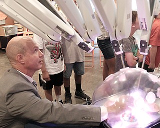 Ryan Ward of Intuitive Surgical Inc. shows off the robotic arms of the Da Vinci surgical system to day campers at OH WOW! The Roger & Gloria Jones Children’s Center for Science & Technology in downtown Youngstown.  On Monday, Ward adjusted a penny the campers magnified and inspected using the system, which is used in a variety of surgeries. 