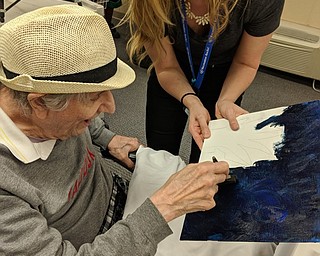 Neighbors | Submitted.The residents at Beeghly Oaks had a "sip and paint" event on Wendesday at the facility. They made a Vincent van Gogh style painting with the assistance of Natalie Hruska. Pictured, resident Gerry Decerbo worked on coloring the background of his painting while Hruska helped him.