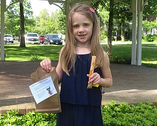 Neighbors | Zack Shively.The children at the Poland library's Storywalk received prizes with every station they visited. These prizes included stickers, bubbles and glowsticks. At the end of the walk, the children got freeze pops as their final reward. Pictured, Sydney DiSibio ended the walk with an orange freeze pop and a paper bag full of prizes.