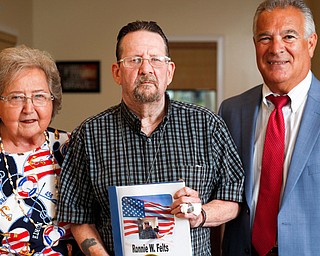 Vietnam War veteran Ronnie Felts, center, stands in the lobby of Washington Square Nursing Home in Warren between Probate Judge James Fredericka and Shirley Barbe-DiVencenzo, a Guardian Angel through Trumbull Probate Court who submitted Felts’ military story to the National Archives.