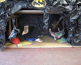 Neighbors | Zack Shively.The Right to Read Week at the school ended on May 11. The theme for the day was blackout Friday, so the students wore black and carried flashlights with them. Pictured, two students read in a reading station designed by the teachers.