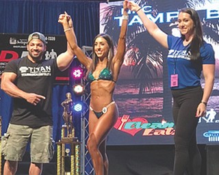 Girard native Katie O’Neill, center, won four bodybuilding titles on June 2 in Florida. Holding her hands are Ron Galup and Heather Eslinger of Titan Medical, the competition sponsor.