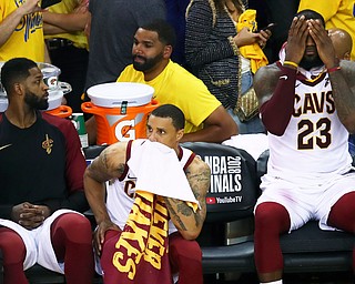 Cleveland Cavaliers forward LeBron James (23) sits on the bench with center Tristan Thompson, left, and guard George Hill during the second half of Game 2 of basketball's NBA Finals against the Golden State Warriors in Oakland, Calif., Sunday, June 3, 2018. The Warriors won 122-103. (AP Photo/Ben Margot)