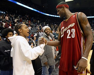 Rapper Bow Wow, left, is greeted by Cleveland Cavaliers' LeBron James as music producer Jermaine Dupri looks on in the background  after the Cavs defeated the Atlanta Hawks Tuesday, Nov. 9, 2004 in Atlanta. (AP Photo/John Bazemore)