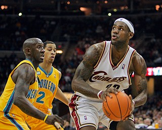 Cleveland Cavaliers' LeBron James, right, coils to shoot against New Orleans Hornets' Bobby Jackson and Jannero Pargo (2) in the fourth quarter of an NBA basketball game Tuesday, Feb. 27, 2007, in Cleveland. James' 35 point sled the Cavaliers to a 97-89 win over New Orleans. (AP Photo/Mark Duncan)