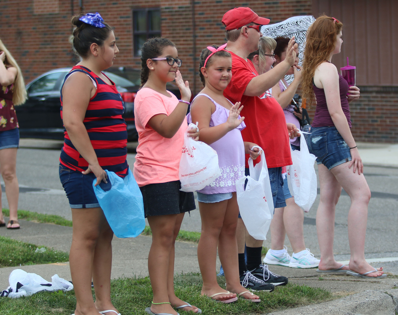 Sofie Previte (10) of Struthers, Zoe Crespo (9), and Gia Crespo (7) of Boardman wave to the floats as they go by during the Struthers Fourth of July Parade on Wednesday afternoon.  Dustin Livesay  |  The Vindicator  7/4/18  Struthers