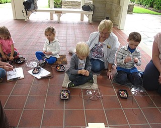 Neighbors | Zack Shively.The children made a craft at the end of the Children's Nature Hour program. They looped string to their plastic bird feeders, then put beads on the strings to personalize their feeders.