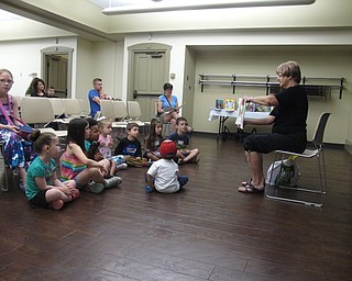 Neighbors | Jessica Harker .Peg Flynn, a Green Team member, read "From Trash to Treasure," to the children at the Rock Out with the Green Team event on June 20.
