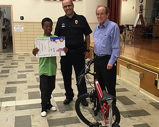 Neighbors | Submitted.Pictured are Sgt. Chuck Hillman, Boardman Optimist Club President, with Market Street fourth-grader Maurice Ware and Atty. Chet Horlick. Ware received a new bike for his winning poster in the Boardman Optimist Club's Safety Poster Coloring Contest.