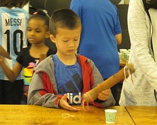 Neighbors | Jessica Harker .Eli Mains played with the rain stick he made at the Explore Water all Around Us event at the Austintown library on June 27.