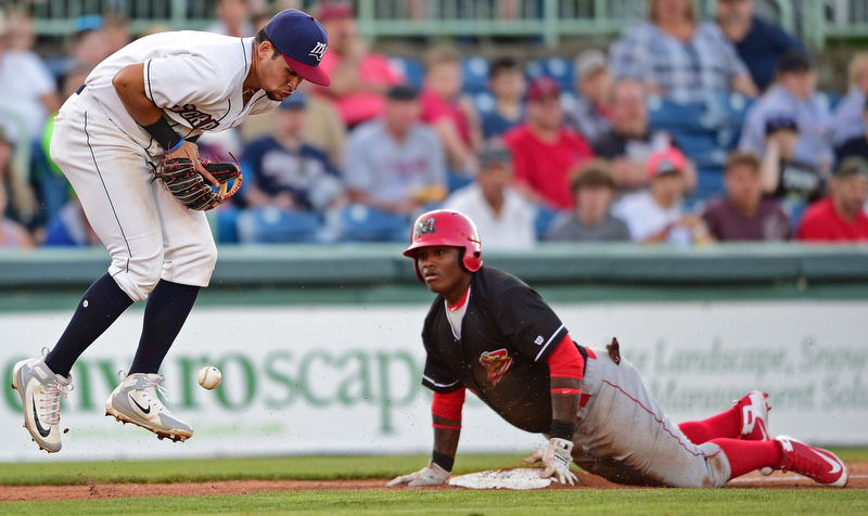 NILES, OHIO - JULY 6, 2018: Mahoning Valley Scrappers' Henry Pujols, left, jumps to block the ball as Batavia Muckdogs' Albert Guaimaro slides into third base for a triple in the third inning of a baseball game against the Batavia Muckdogs, Friday, July 6, 2018, in Niles. DAVID DERMER | THE VINDICATOR