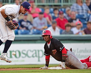 NILES, OHIO - JULY 6, 2018: Mahoning Valley Scrappers' Henry Pujols, left, jumps to block the ball as Batavia Muckdogs' Albert Guaimaro slides into third base for a triple in the third inning of a baseball game against the Batavia Muckdogs, Friday, July 6, 2018, in Niles. DAVID DERMER | THE VINDICATOR