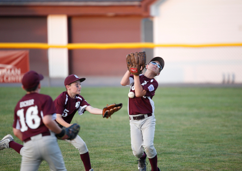 Boardman's Dominic Krol,right. misses the ball while Ivan Rudiak, center, and Grayson Eicher try to help during the Little League baseball 11-U playoff game against Canfield on Wednesday.
