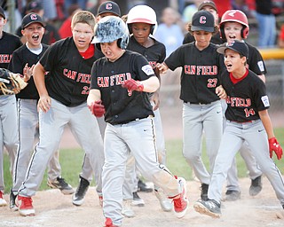 Canfield celebrates as Dylan Mancini runs into home after hitting a home run during the Little League baseball 11-U playoff game against Boardman on Wednesday.