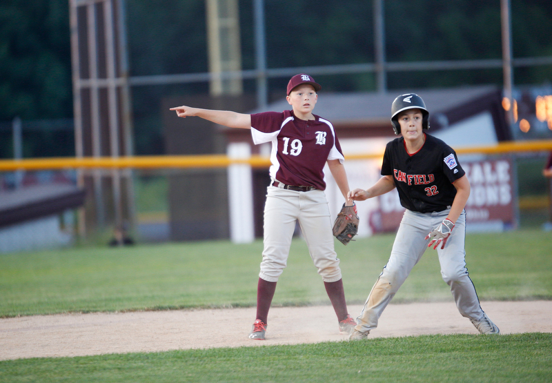 Boardman's Mason Nawrocki points to third as Canfield's Angelo Delucia takes a lead during the Little League baseball 11-U playoff game on Wednesday.