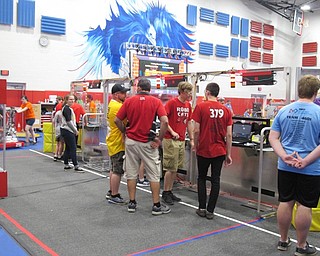 Neighbors | Jessica Harker.Team members from the RoboCats, from Girard, stood behind the glass looking into the arena preparing for the next round of the tournament on June 30.