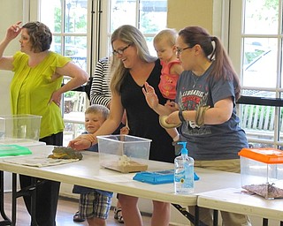 Neighbors | Jessica Harker.A Poland librarian held the ball python while children and their families lined up to pet the other animals present at the library June 28 for the Felgers exotic animals event.