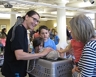 Neighbors | Jessica Harker.Beth Felger encouraged children to pet the lion head rabbit with the marmoset monkey on her shoulder at the Poland library on June 28.
