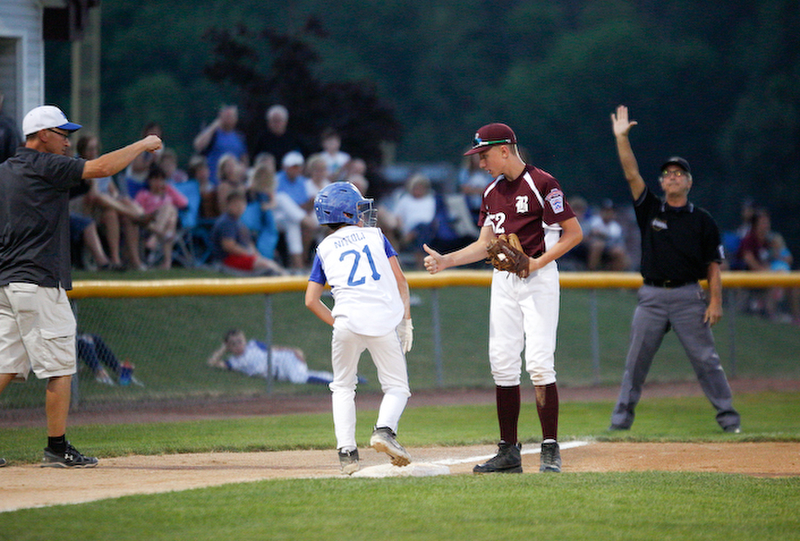 Boardman's Jack Ericson asks Poland's Danny Nitolli if he's okay after Nitolli dove into third during the 12u championship game at Field of Dreams on Friday.