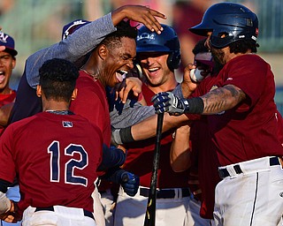 NILES, OHIO - JULY 15, 2018: Mahoning Valley Scrappers' Hosea Nelson is mobbed by his teammates at home plate after hitting a a walk-off home run off Hudson Valley Renegades relief pitcher Jesus Ortiz in the ninth inning, Sunday, July 15, 2018, in Niles. The Scrappers won 8-6. DAVID DERMER | THE VINDICATOR