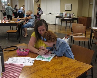 Neighbors | Jessica Harker .Allie Mrofchak and her mother Danielle colored a photo as part of the June 22 Camp Out at the Library at the event held in Poland.