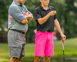 DIANNA OATRIDGE | THE VINDICATOR Jake Sylak, from Mineral Ridge, strategizes his next shot with his dad and caddie, Jason Sylak, during the final round of the Greatest Golfer junior tournament at Avalon Lakes in Howland on Saturday.