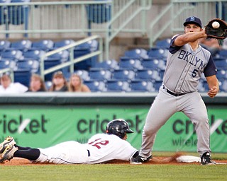 Scrappers' Jose Fermin dives back to first as Cyclones' Chase Chambers catches the ball during Tuesday night's game.