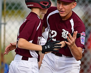 NORTH CANTON, OHIO - JULY 24, 2018: Boardman's Evan Sweder, left, is congratulated by Jack Ericson after scoring a run on a hit by Zach Ganser in the first inning of a Little League baseball game, Tuesday night in North Canton. DAVID DERMER | THE VINDICATOR
