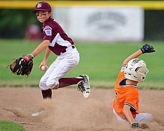 NORTH CANTON, OHIO - JULY 24, 2018: Boardman's Anthony Triveri, left, looks to first after forcing out Ironton's Tommy Sheridan at second base in the third inning of a Little League baseball game, Tuesday night in North Canton. DAVID DERMER | THE VINDICATOR