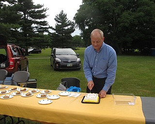 Neighbors | Jessica Harker.Mark Luke, a member of the Boardman Kiwanis, cut a cake that was sold during the BHS jazz band concert for the Music in the Park concert series on June 21.